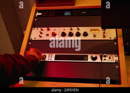 DJ Using Musical Equipment In Studio Stock Photo
