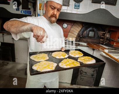 Daily production of bread baked with wood oven with traditional method. Stock Photo