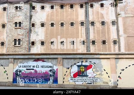 Barcelona, SPAIN - JULY 5, 2024: Weathered exterior of an iconic prison in Barcelona adorned with striking graffiti art symbolizing freedom and resist Stock Photo