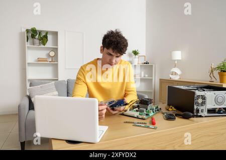 Young technician repairing computer at table in service center Stock Photo