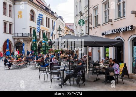 The world-famous Hofbräuhaus on Platzl in Munich's city center with tourists in the beer garden Stock Photo