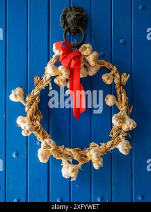 garlic wreath on an old wooden blue door Stock Photo