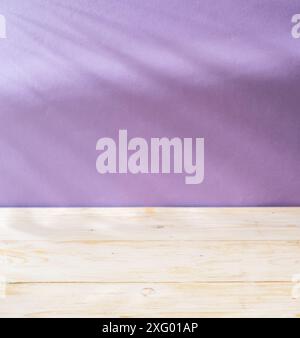 Blurred shadow of  leaves on the violet wall and table top in the foreground. Summer concept. Stock Photo