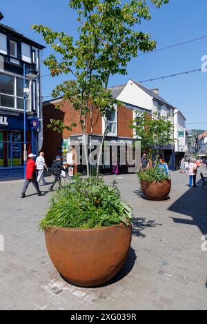 Shopping street with red metal planters, Abergavenny, Wales, UK Stock Photo