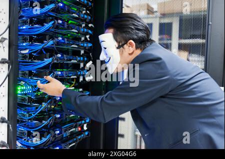 Masked Hacker in Computer Server room Concept .Editorial photo Stock Photo