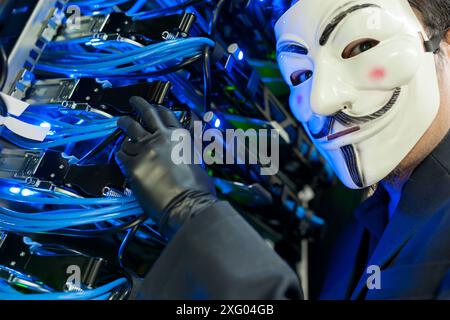Masked Hacker in Computer Server room Concept .Editorial photo Stock Photo