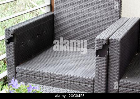 Old wicker balcony furniture with holes. Furniture for the terrace. Background. Texture. Horizontal Stock Photo