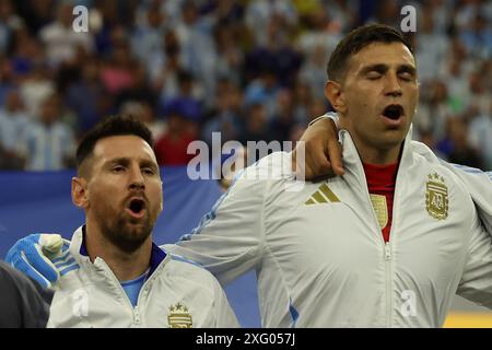 Argentina's forward Lionel Messi (L) and goalkeeper Emiliano Martinez sing the national anthem before the Copa America USA 2024, quarterfinal match between Argentina and Ecuador, at NRG stadium in Houston, on July 4, 2024. Stock Photo