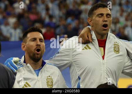 Argentina's forward Lionel Messi (L) and goalkeeper Emiliano Martinez sing the national anthem before the Copa America USA 2024, quarterfinal match between Argentina and Ecuador, at NRG stadium in Houston, on July 4, 2024. Stock Photo