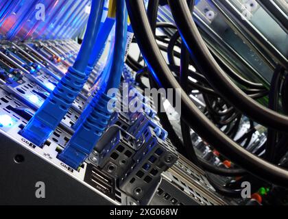 close up of network cables connected to server racks in data center room. Stock Photo