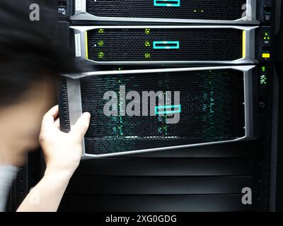 Man fixing server in data center room . Stock Photo