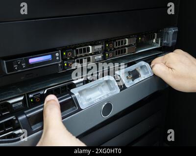 Man fixing server in data center room . Stock Photo