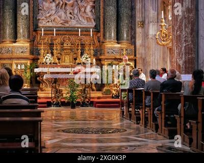 Rome, Italy - July 21, 2019: People listen to a priest preach at mass in a Catholic church. Stock Photo