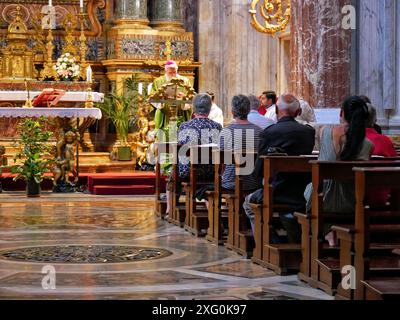 Rome, Italy - July 21, 2019: People listen to a priest preach at mass in a Catholic church. Stock Photo