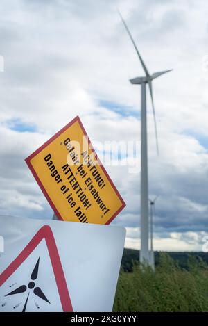 Wind Turbines with a caution sign warning of the dangers of approaching the turbine Stock Photo