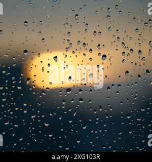 Raindrops on a window pane after rain at sunset Stock Photo