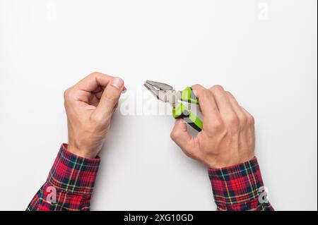 Man holding pliers in his hand on a white background Stock Photo