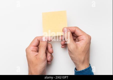 Hands of an office worker hold colored stickers for notes on a white ...