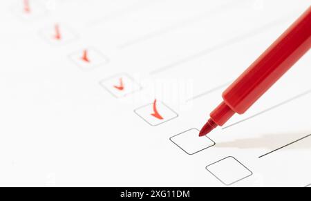 Red marker with markers on the checklist sheet. Checklist completed task concept. Copy space Stock Photo