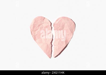 Broken heart made of pink crumpled paper isolated on white background Stock Photo