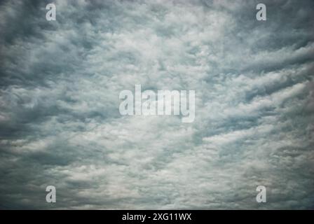 Moody overcast sky background, fleecy clouds texture, ominous skies in cold windy weather Stock Photo