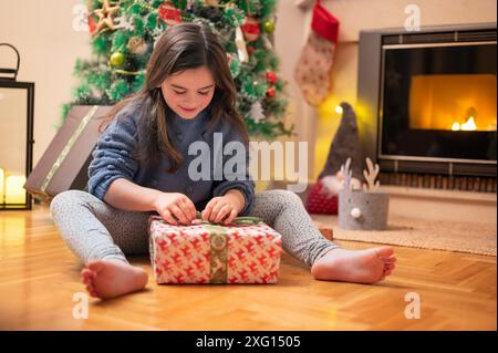 Cute girl opening christmas present. High quality photography Stock Photo