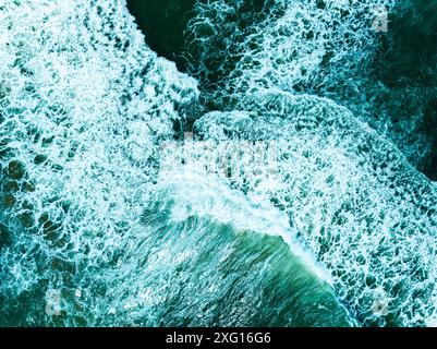 Overhead view turquoise stormy ocean waves with white foam in the ocean,Sea water with splashes and foam, Top view waves background, Natural backgroun Stock Photo