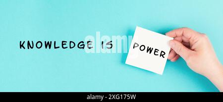 The phrase knowledge is power is standing on a paper, coaching and education concept, development of personal potential, cognition and willpower Stock Photo