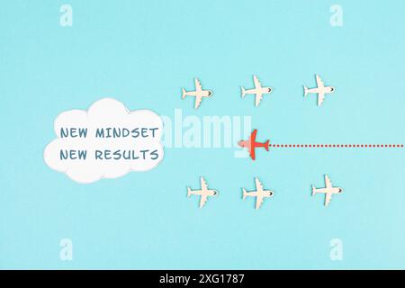 Red airplane is flying to the cloud with the words new mindset new results, changing lifestyle, coaching and improvement concept, positive thinking Stock Photo