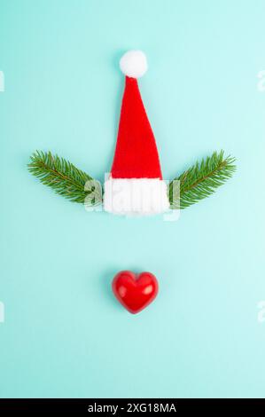 Face of a reindeer with a red heart nose, fir antlers and a santa claus hat, merry christmas greeting card Stock Photo