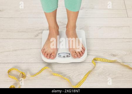 Woman standing on floor scales indoors, above view Stock Photo