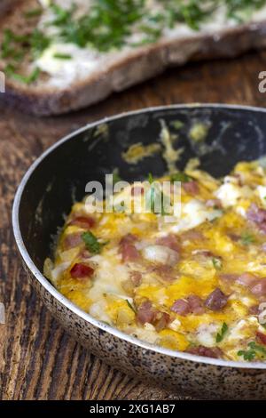 Scrambled eggs in a pan on wood Stock Photo