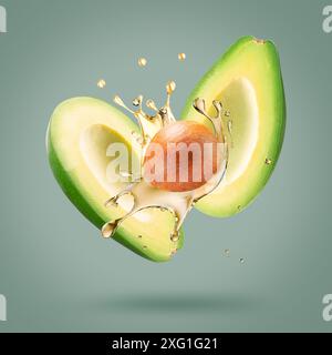 avocado with oil splash on a light green background. Stock Photo