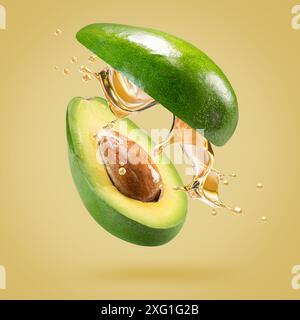 avocado with oil splash on a light green background. Stock Photo