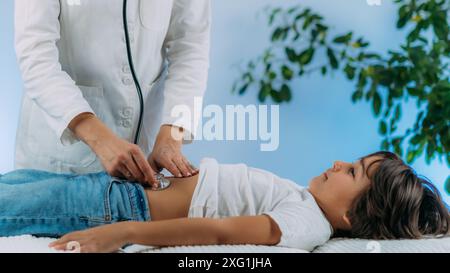 Pediatrician gastroenterologist doing abdominal examination with stethoscope. Stock Photo