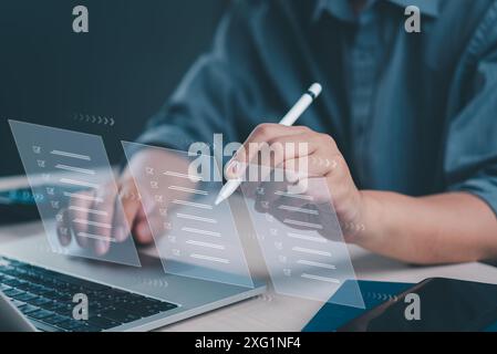 Close-up of hands using a futuristic interface for task management, and digital checklist satisfaction on a laptop. Stock Photo