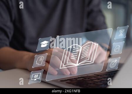 A man interacts with a digital book and educational icons on a futuristic interface. Stock Photo