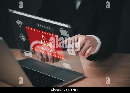A person is pointing at a computer screen that has a red warning sign that says Cyber Security. The person is wearing a suit and he is in a profession Stock Photo