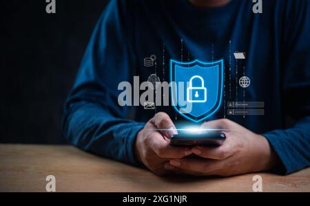 Person holding a smartphone with a digital shield and lock icon. Emphasizes data protection and cybersecurity. Ideal for technology, internet safety, Stock Photo