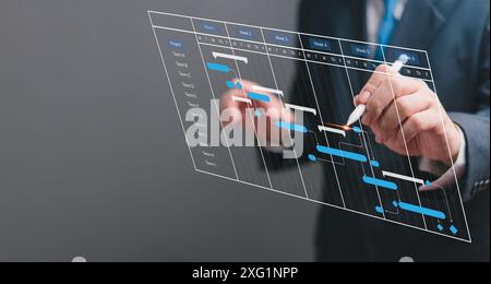 Businessperson managing project schedule with digital Gantt chart. Modern project planning, task management, progress tracking. Professional workspace Stock Photo