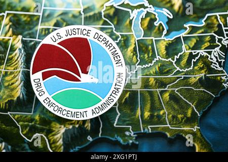 KYIV, UKRAINE - JUNE 26, 2024 U.S. Justice Department Drug Enforcement Administration coat of arms on paper map of United States of America Stock Photo