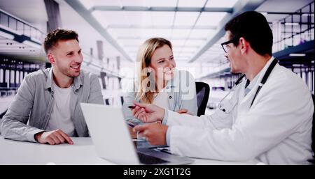 Smiling dentist sharing X-ray results with patients in dental office, discussing treatment options and providing digital care. Stock Photo