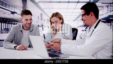 Smiling dentist sharing X-ray results with patients in dental office, discussing treatment options and providing digital care. Stock Photo