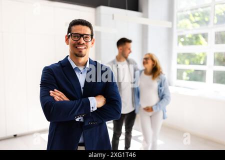 Professional Real Estate Agent And Happy Clients Couple In New Home Stock Photo