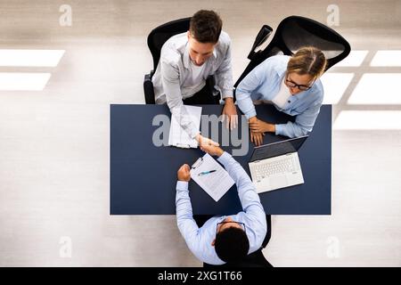Professional Consultant Guide Couple in Meeting with Advisor for Financial Planning and Real Estate Investments in High Angle View. Stock Photo