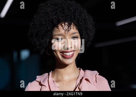 Smiling woman in business attire posing confidently in office environment Stock Photo