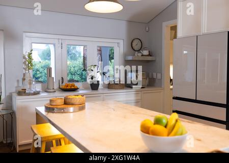 Modern kitchen with marble countertop, fruit bowl, and coffee machine on counter, copy space Stock Photo