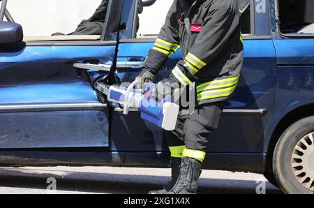 Firefighting Car Scissors A firefighter using hydraulic cutting shear during vehicle extrication ...