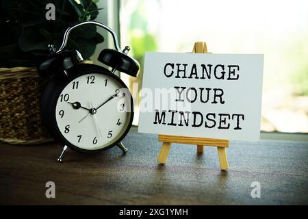 Change your mindset text message on paper card with wooden easel on wooden table background, inspiration motivation concept Stock Photo