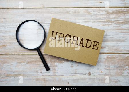Upgrade text message and magnifying glass with space copy on wooden background Stock Photo